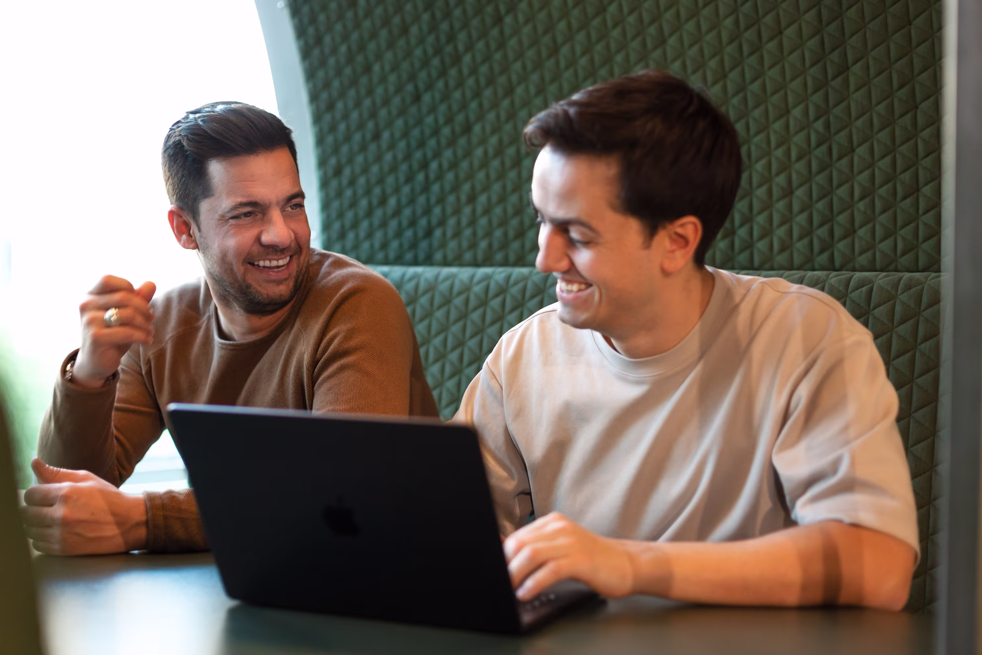 Twee mensen bespreken samen een websiteproject op een laptop
